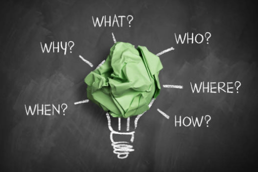 Lightbulb made of crumpled green paper surrounded by why, what, who and how questions - commercial and brand strategy